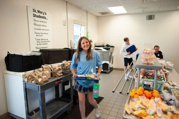 A student walking out with food in the campus cafeteria.