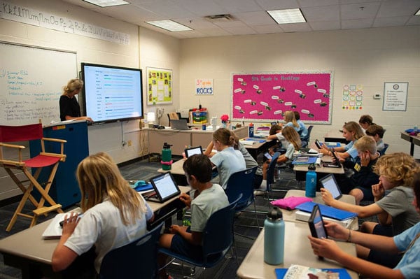 An upper school classroom with students on iPads doing an interactive activity.