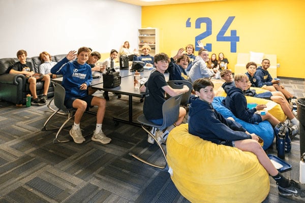 A classroom of older boys sitting in chairs and beanbags.